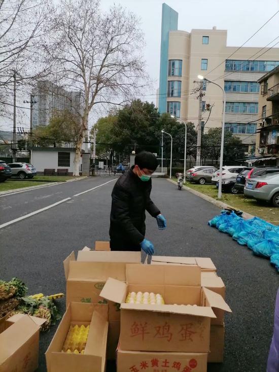 陈新强在家属院帮忙搬运分发团购物资