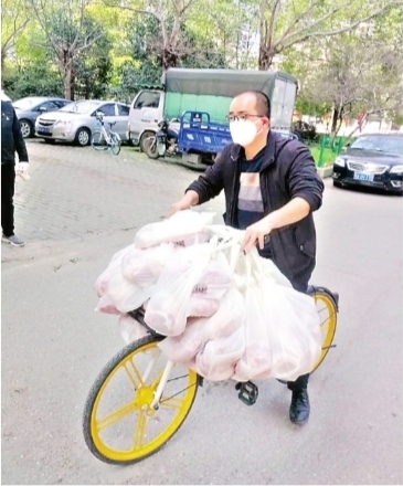 王亮在车把上挂满了业主们团购的冻猪肉 市民甘女士供图