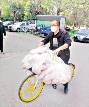 王亮在车把上挂满了业主们团购的冻猪肉 　市民甘女士供图