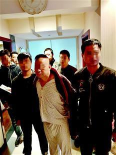 图为:张潮新(中)在黄石的住处被警方抓获