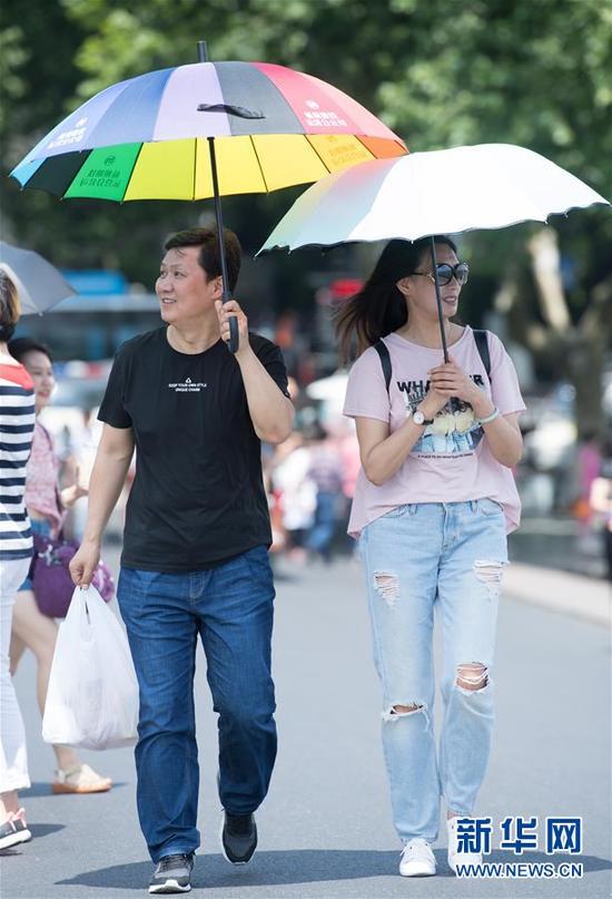 5月16日,游人在杭州西湖断桥上游览。近日,浙江杭州最高温度持续35摄氏度以上。据浙江省气象台分析,5月15日至17日三天受副高边缘影响,浙江将持续高温,全省除沿海地区外大部最高气温达35摄氏度至37摄氏度。新华社记者翁忻旸摄