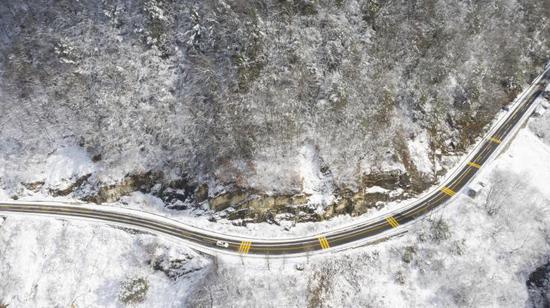 铺设热熔除冰系统的路面与山上积雪成鲜明对比