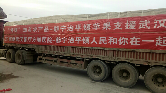 图为甘肃静宁县治平镇捐赠湖北的苹果准备发车。