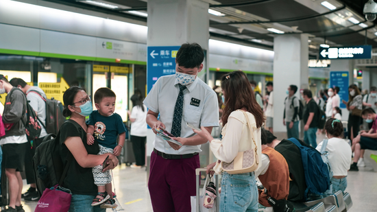 武汉地铁“姚婕志愿服务总队”在武汉火车站发放《乘地铁 游武汉》手册
