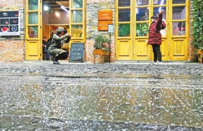 17日下午，汉口里商业街下了一地的小冰粒，一位妈妈在给孩子拍照 记者许魏巍 摄