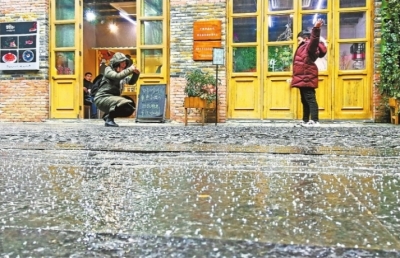 17日下午，漢口里商業(yè)街下了一地的小冰粒，一位媽媽在給孩子拍照 記者許魏巍 攝
