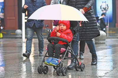 12月5日，汉口航空路，人们裹着厚厚的冬装在雨中疾行
