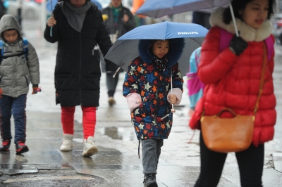 新一轮雨水又要来了。昨日,孩子们在家长陪伴下冒着风雨上学记者肖僖 摄