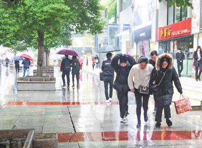 12月5日，江城寒雨阵阵，江汉路步行街上，不少年轻人在雨中逛街购物记者苗剑 摄