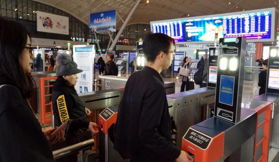 旅客们通过刷脸、刷证进站、乘车。(刘卫兵 摄)