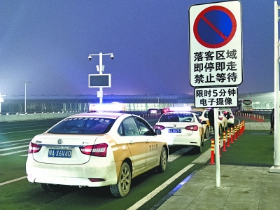 机场出发厅5号门外下客区，违停的出租车