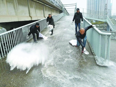 硚口区城管委水车队环卫工人撒盐防止人行天桥结冰 通讯员易虎 摄