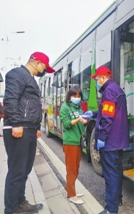 22日8时30分许,东西湖大道额头湾公交站,准备上车的乘客接受体温测量 长江日报记者张宁 摄