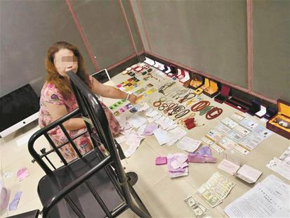 图为:在朱某英家中,民警查获了大量金银首饰、玉镯、串珠等物品