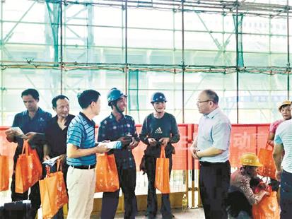 图为:洪山区司法局党组书记、局长刘光平(右一)深入工地,与农民工兄弟交谈