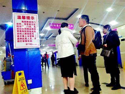 医托（右一）在医院内“拉客”，一旁的举报医托提示十分醒目
