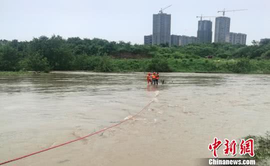 两名男子突遇河水上涨被困在河中心 江继乐 摄