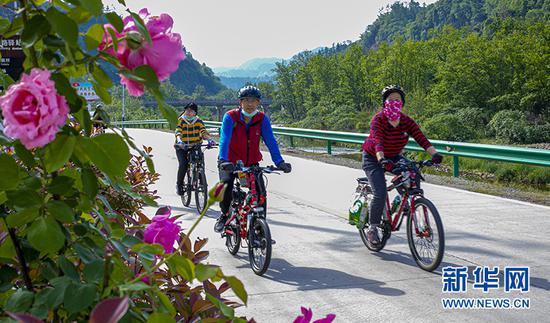 图为湖北宜昌修建的农村公路成为市民旅游休闲好去处，促进了当地旅游业发展。新华网发