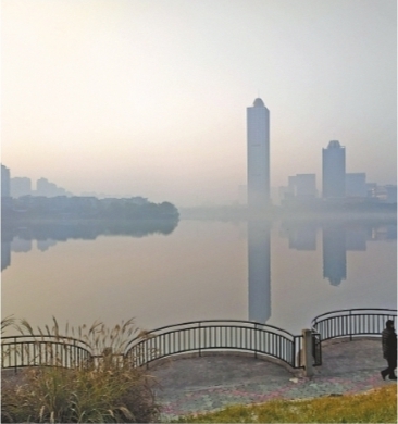 12月17日晨，薄雾随着太阳的升起，在金银湖的水天之间织出朦胧的轻纱 记者李永刚 摄