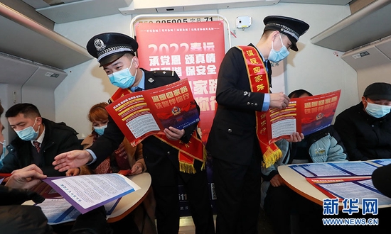 图为1月17日，在D3044次列车上，武汉铁路公安处汉口乘警支队党团员民警为旅客开展爱民服务和法制安全宣传活动。新华网发 胡金力摄