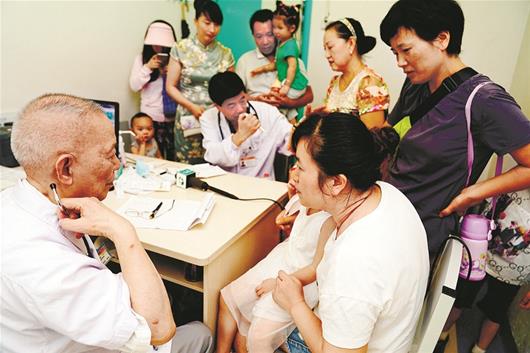 圖為桂世澄、桂衛(wèi)星父子“同室坐診”