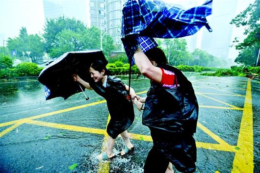 图为9月16日，强台风“山竹”来袭。在深圳市南山区科技园，行人在风雨中前行 新华社发