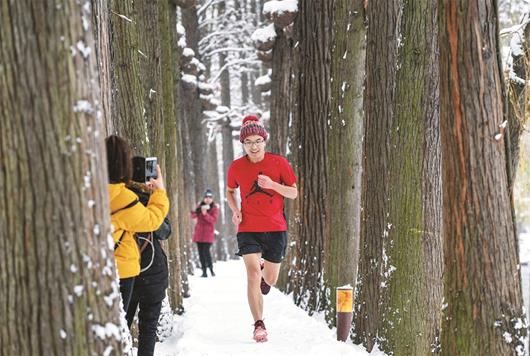 图为：东湖绿道内，一位跑步爱好者在雪中锻炼