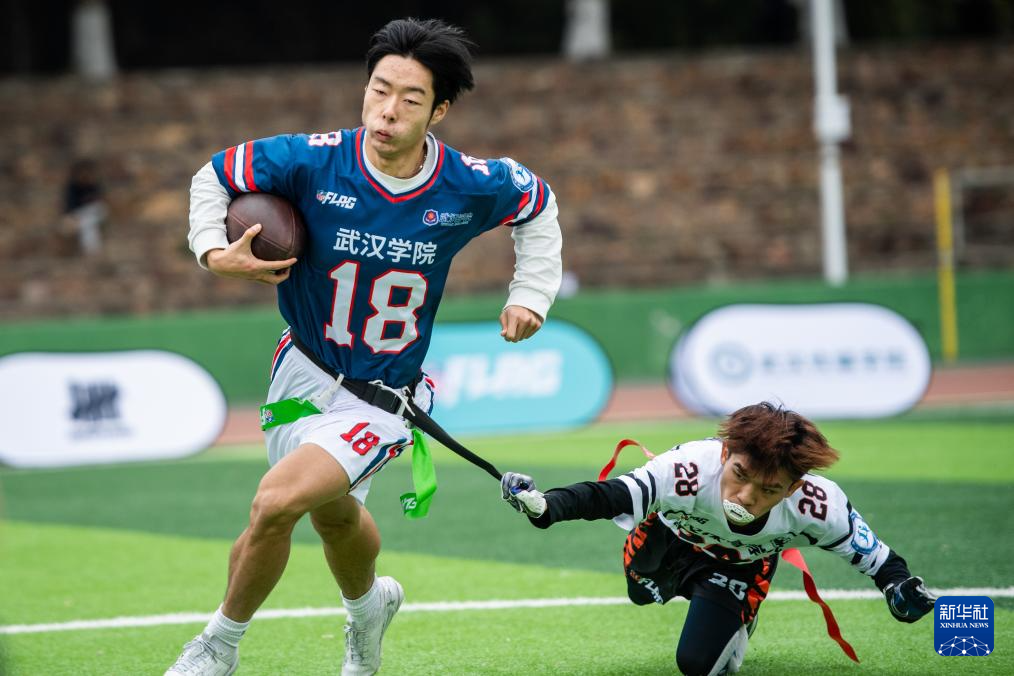 12月9日,武汉学院队球员陈童(左)和武汉体育学院队球员陈凯鑫在比赛中拼抢。