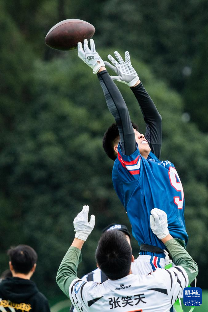 12月9日，武汉学院队球员金子超（上）和武汉体育学院队球员张笑天在比赛中拼抢。