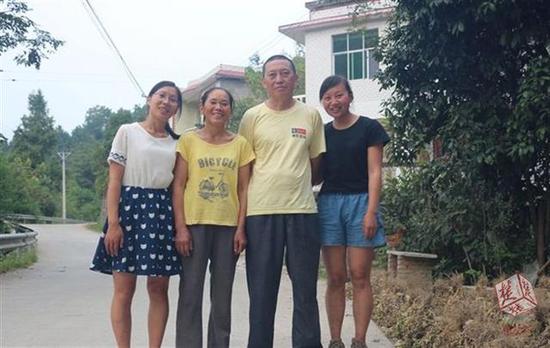 一家人在村口合影。左起:覃会(妹妹)、徐兰英、覃光辉、覃利萍(姐姐)