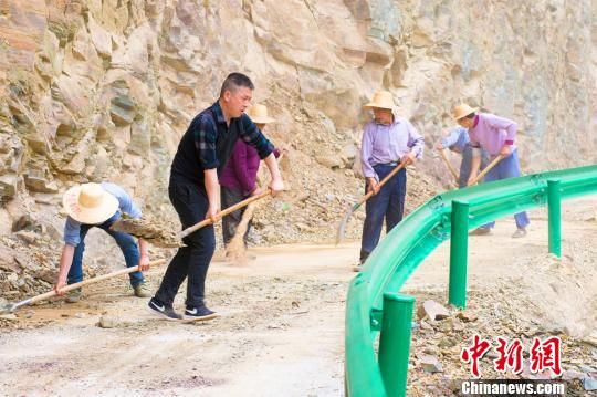 左青松（左2）和村民一起维护茶丘公路 杨威 摄