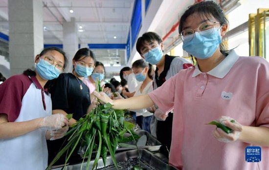 6月4日，湖北省宣恩县一中的高三学生在展示包好的粽子。
