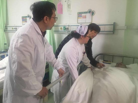 万慧仙和查房的医生询问王一武,床头上的收音机放着音乐。本文图片均为 周莉 陈舒 摄