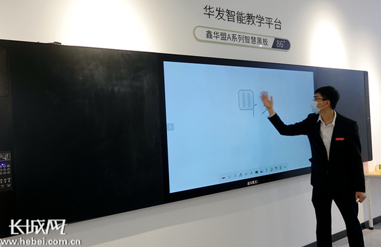 华发教育工作人员展示智慧黑板的使用功能。 记者 信贺宁 摄
