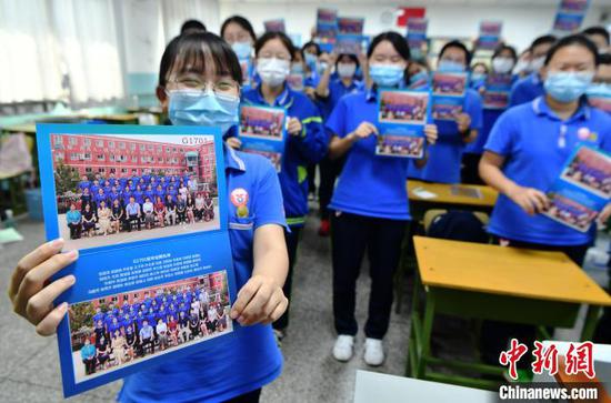  图为同学们开心的展示毕业照。　翟羽佳 摄