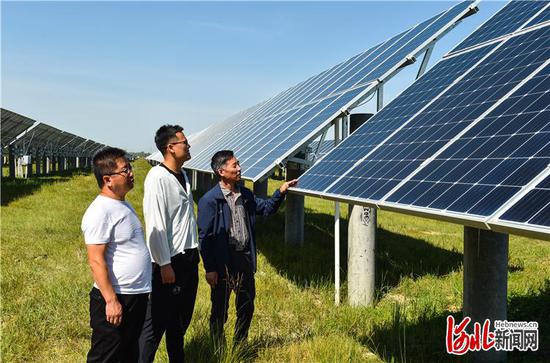 8月29日，工作人员查看康保县北郝家营村级光伏扶贫联建电站。河北日报记者耿辉摄