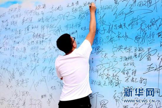 学生在签名。张鹏 摄