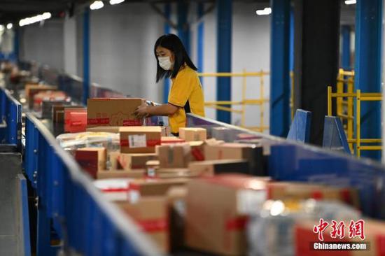 资料图:物流工作人员分拣快件。中新社记者 崔楠 摄