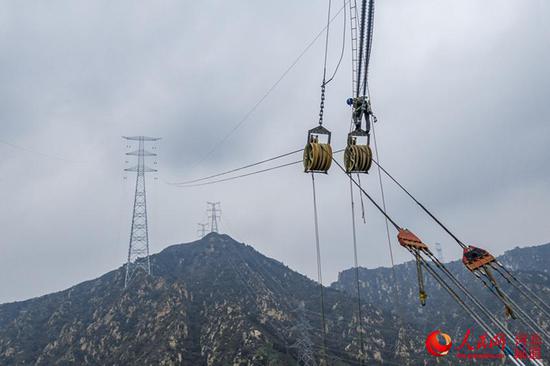 7月8日，张北-雄安1000千伏特高压输变电工程正在进行乌龙沟跨越施工。 赵洁、马千里摄