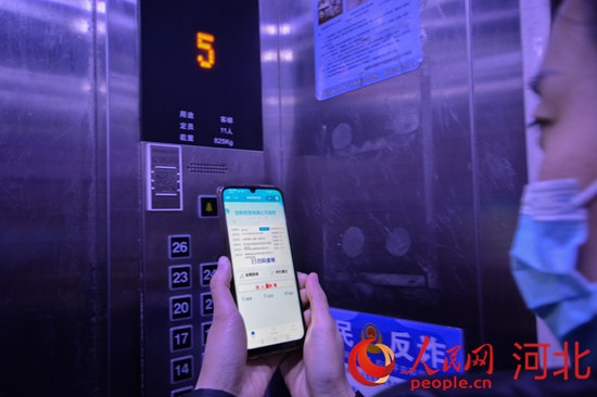 邯郸市邯山区阿尔卡迪亚碧水湾小区居民扫码查看电梯信息。李昊摄