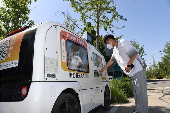 在雄安市民服务中心,市民在智能无人售卖车购买饮料(2022年5月27日摄)。新华社记者 朱旭东 摄