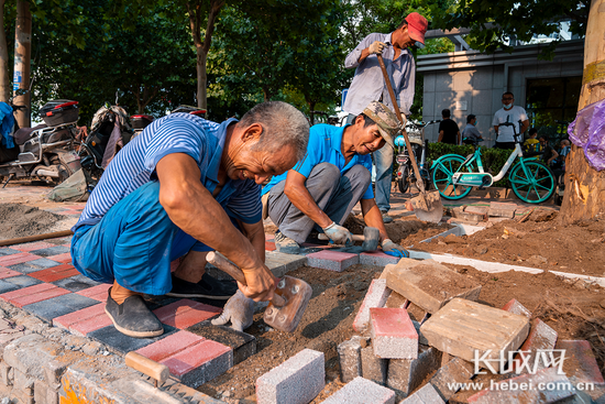 7月24日，施工人员正在该路段铺设地砖。长城网记者 康义涵 摄