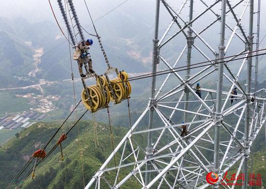 7月8日，张北-雄安1000千伏特高压输变电工程正在进行乌龙沟跨越施工。 赵洁、马千里摄