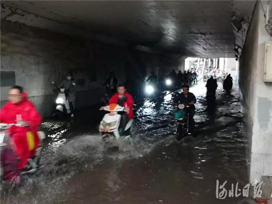 5月12日,市民涉水通过地道桥。当日,石家庄突降大雨,市区部分路段积水严重。
