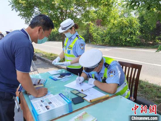 图为河北高速交警为危化品运输车辆人员进行在册登记。 李洋 摄