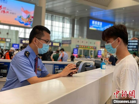 资料图:车站工作人员帮助旅客查询行程信息 于莉 摄