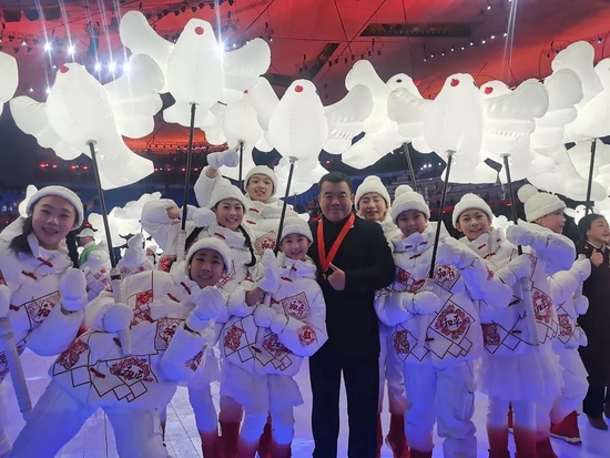参加国旗传递仪式的石家庄二中实验学校副校长赵智峰与小演员合影。