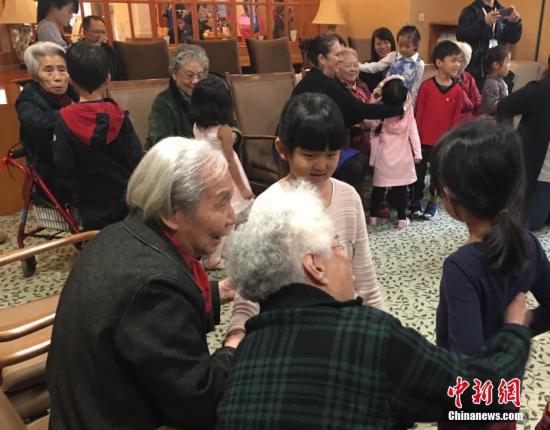 资料图：养老院中，老人们与幼儿园小朋友一起做游戏。中新社记者 杜燕 摄