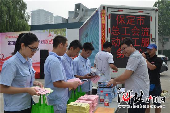 8月1日上午,保定市总工会流动职工服务中心启动仪式举行。图为流动职工服务队向企业职工发放普法资料。 吕新生摄