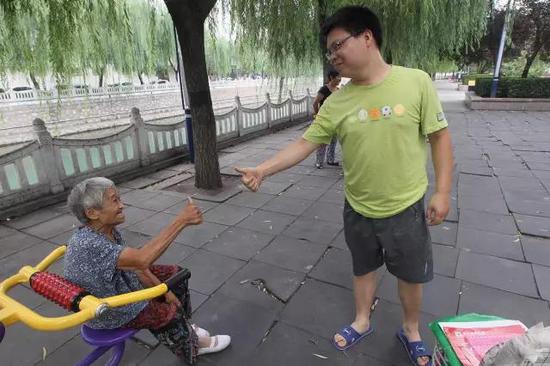 一位年轻人向老人竖起了大拇指
